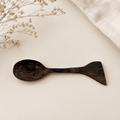 Håndlaget teskje i mørk teak med dobbel funksjon som skje og liten spatel – perfekt til te, kaffe, honning og krydder.