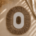 Håndlaget veggdekor i skjell og alang-alang fra Bali i naturlige beige og hvite toner.